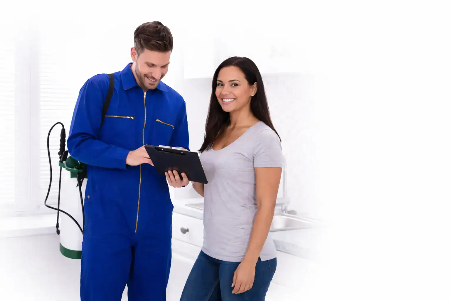 Pest control technician discussing treatment plan with homeowner in kitchen during inspection